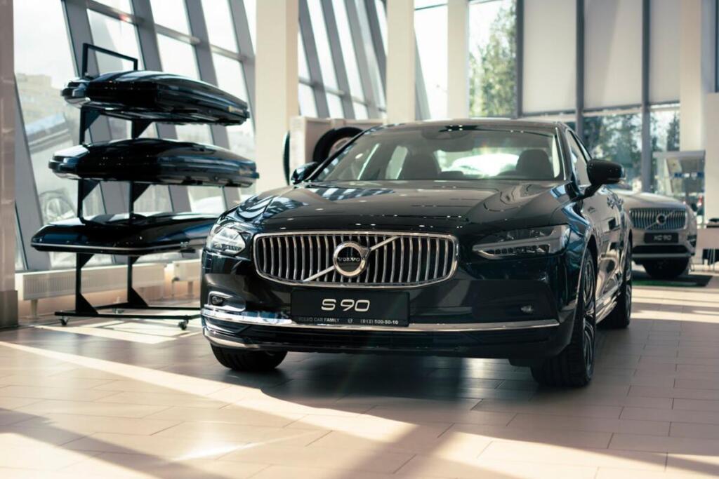 melans krāsas volvo S90 auto salonā, fonā auto jumta bagāžnieki